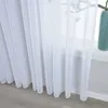 A close-up view of white sheer curtains hanging in front of a window. Produktbild-Vorschau