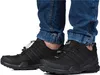 A person wearing blue jeans and black Adidas Terrex hiking shoes. Anteprima dell’immagine prodotto