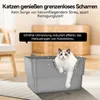 A cat is sitting in a gray litter box with some litter scattered around it. There is text overlaying the image. Produktbild-Vorschau