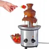 A hand is dipping a strawberry into a chocolate fountain. Podgląd zdjęcia produktu
