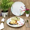 A table setting with plates of food and decorative plants. Produktbild-Vorschau