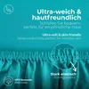 A close-up of teal-colored fabric with text overlays describing its features. Produktbild-Vorschau
