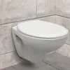 A white wall-mounted toilet with a closed lid, set against a tiled wall and floor. Produktbild-Vorschau