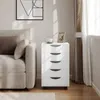 A white rolling storage cart with five drawers sits next to a sofa in a living room. Produktbild-Vorschau