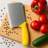 A top-down view of a knife and vegetables on a cutting board. Produktbild-Vorschau