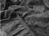 A close-up view of a crumpled dark gray fabric, likely a bedsheet, showing its texture and elasticized edge. Náhled obrázku produktu