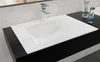 A white rectangular sink with a silver faucet is installed on a black countertop. Náhľad obrázku produktu