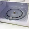 Close-up view of the inside of a microwave oven, showing the glass turntable. Anteprima dell’immagine prodotto