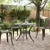 A patio table and chairs set on a brick patio in a garden setting. Náhľad obrázku produktu
