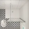 A top-down view of a modern bathroom shower area with geometric patterned tiles and a glass shower screen. Produktbild-Vorschau