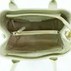 The inside of a light green handbag is shown. Produktbild-Vorschau