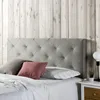 A tufted headboard is shown on a bed with pillows and bedding. Produktbild-Vorschau