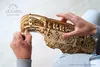 Hands assembling a wooden mechanical model. Produktbild-Vorschau