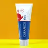 A tube of Curaprox kids toothpaste against an orange and yellow background. Anteprima dell’immagine prodotto