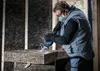 A man wearing safety gear is using a reciprocating saw to cut through a large block of insulation material. Voir les images du produit