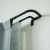 A black double curtain rod mounted on a white wall, with light gray curtains hanging from it. Podgląd zdjęcia produktu