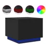 A black cube-shaped coffee table with blue LED lighting around its base, shown against a white background. Several circular insets above the table show close-ups of its corners with different color lighting options (gray, red, green) and a color wheel. Voir les images du produit