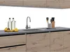 A modern kitchen counter with a sink, faucet, bottles, and fruit. Náhled obrázku produktu