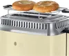 A close-up view of a cream-colored retro toaster with a chrome top, holding two bagels on a warming rack. Produktbild-Vorschau