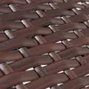 A close-up view of a woven brown poly-rattan material. Produktbild-Vorschau