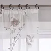 Close-up of sheer curtains with a floral pattern hanging on a curtain rod. Produktbild-Vorschau