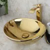 A gold basin sink with a gold faucet on a marble countertop. Anteprima dell’immagine prodotto
