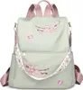 A light green backpack with pink floral embroidery and butterfly accents. Náhľad obrázku produktu
