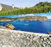 A scenic view of a bay filled with sailboats, with a house and trees in the background, printed on a fence banner. Produktbild-Vorschau