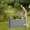 A woman is gardening in a raised garden bed in a backyard setting. Náhled obrázku produktu
