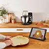 A kitchen scene with a stand mixer, a pie crust being prepared, and a tablet showing a recipe. Produktbild-Vorschau