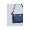 A close-up shot of a navy blue Lacoste satchel bag against a textured light gray background. Produktbild-Vorschau