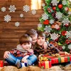 Three children are sitting in front of a decorated Christmas tree, surrounded by snowflakes and presents. Produktbild-Vorschau