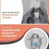 A split image showing CPAP mask and tubing holders mounted on a wall and a close-up of the organized CPAP equipment. Produktbild-Vorschau