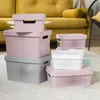 Several plastic storage boxes with lids are stacked and arranged on a rug in a room. Náhľad obrázku produktu