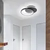 A modern hallway with white walls and doors, featuring a contemporary black ceiling light. Produktbild-Vorschau