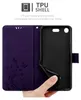 A hand is shown inserting a phone into a purple flip case with a floral design. Náhľad obrázku produktu