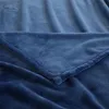 A close-up view of a folded dark blue blanket, showing its soft texture and stitching. Produktbild-Vorschau