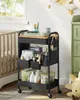 A nursery room with a baby crib, a changing table, and a rolling cart filled with baby supplies. Produktbild-Vorschau