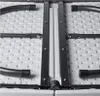 A close-up view of the underside of a folding table, showing the metal frame and plastic surface. Produktbild-Vorschau