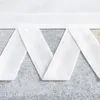 A close-up view of a white fabric blind with a decorative folded edge. Produktbild-Vorschau