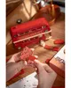 Hands assembling a wooden model of a red London double-decker bus. Náhľad obrázku produktu
