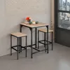 A bar set with a table and two stools in a room with a brick wall and a large window overlooking a city. Náhled obrázku produktu