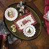 Christmas-themed tableware arranged on a coffee table. Produktbild-Vorschau