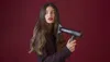 A woman with long brown hair holding a hairdryer. Náhled obrázku produktu