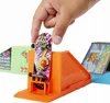A hand is placing a miniature skateboard on a toy skatepark ramp. Produktbild-Vorschau