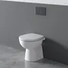 A white toilet bowl is shown against a gray wall and concrete floor. Anteprima dell’immagine prodotto