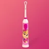 A pink electric toothbrush with a Paw Patrol character on it, set against a pink background. Anteprima dell’immagine prodotto
