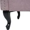 Close-up view of the legs and bottom edge of a pink upholstered chair. Voir les images du produit