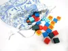 A drawstring bag with a blue and white tile pattern is spilling out colorful square tiles onto a white surface. Anteprima dell’immagine prodotto