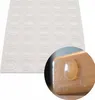 A sheet of clear, oval-shaped adhesive bumper pads is shown along with a close-up of one pad applied to a wooden surface. Produktbild-Vorschau